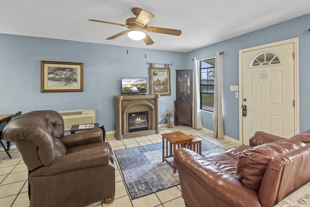 living room with light tile patterned flooring, ceiling fan, and a glass covered fireplace