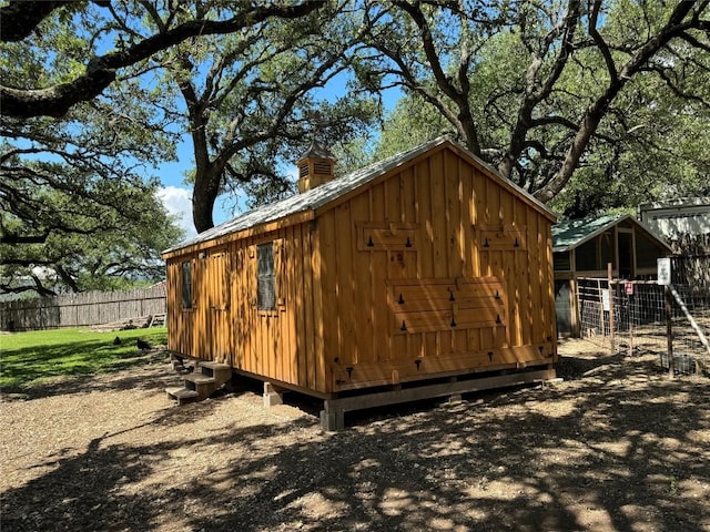 view of outbuilding with fence and an outdoor structure