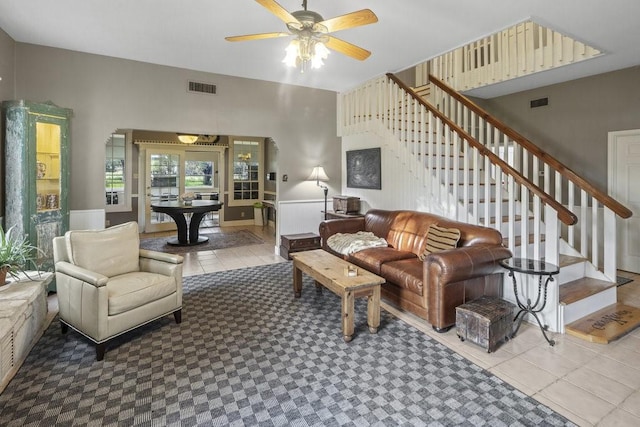 living room featuring stairway, visible vents, and a ceiling fan