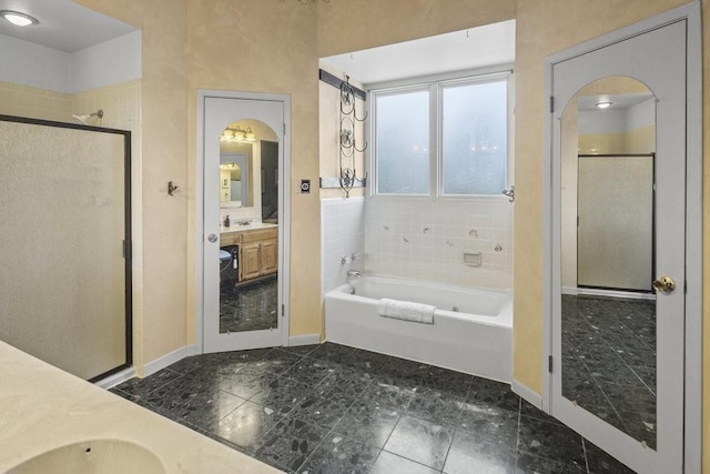 full bath with baseboards, a shower stall, a garden tub, and vanity