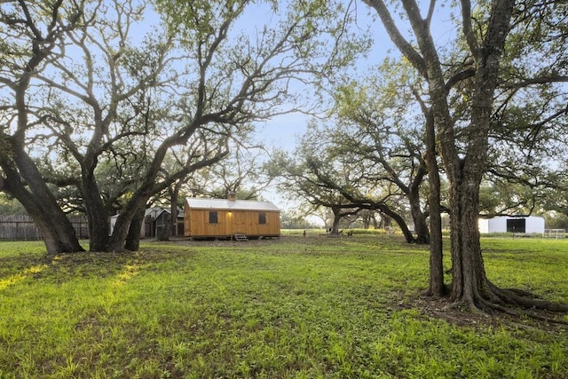view of yard with fence, an outbuilding, and a storage shed