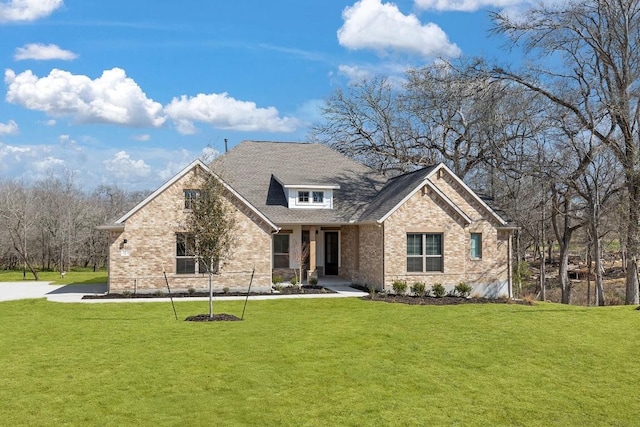 view of front facade featuring brick siding and a front yard