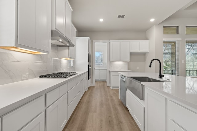 kitchen featuring stainless steel appliances, light countertops, and white cabinets