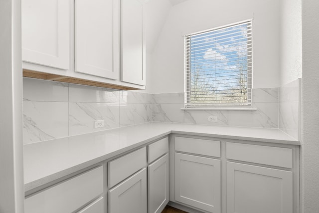 kitchen with light countertops, tasteful backsplash, and white cabinetry