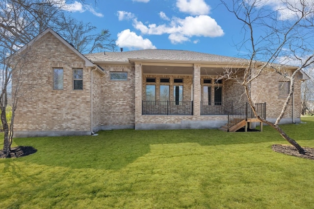 back of house featuring stairs, a lawn, and brick siding