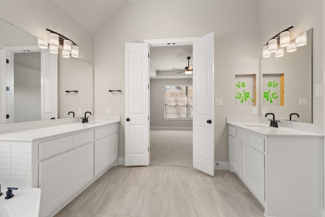 full bath featuring vaulted ceiling, two vanities, and a sink