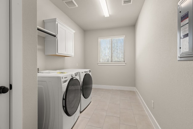 washroom with light tile patterned floors, visible vents, baseboards, washer and dryer, and cabinet space