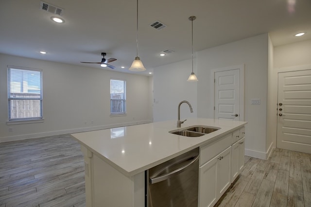 kitchen featuring stainless steel dishwasher, sink, light wood-type flooring, and an island with sink