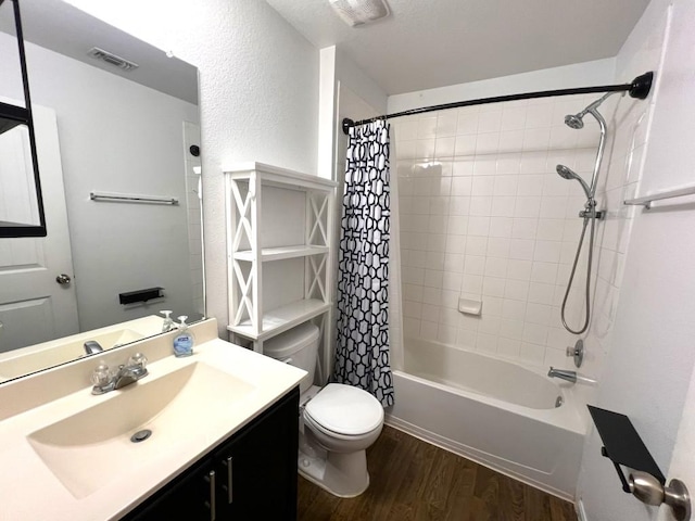 bathroom featuring visible vents, toilet, wood finished floors, shower / bath combination with curtain, and vanity