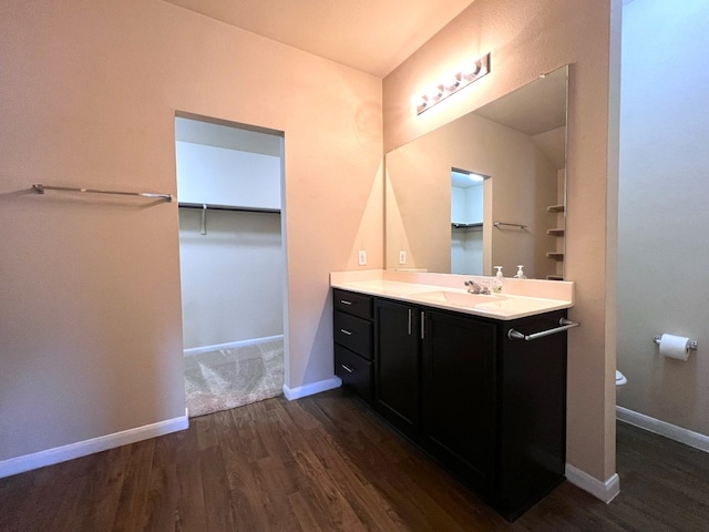 bathroom featuring wood-type flooring, toilet, and vanity