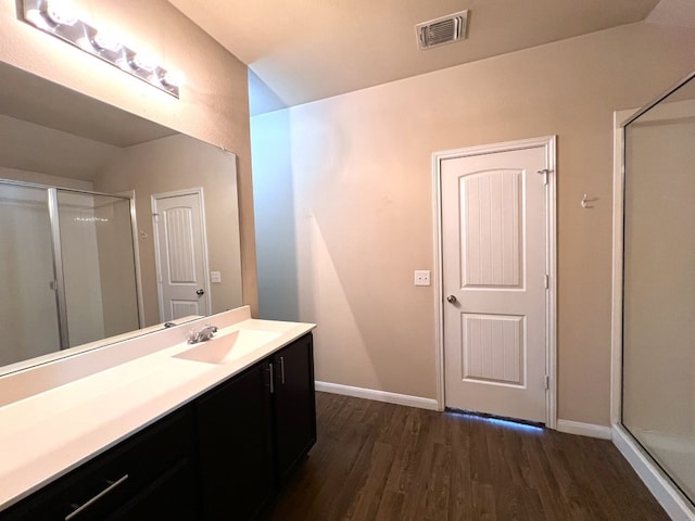 bathroom featuring hardwood / wood-style floors, a shower with door, and vanity