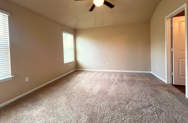 empty room with ceiling fan, a wealth of natural light, and carpet flooring