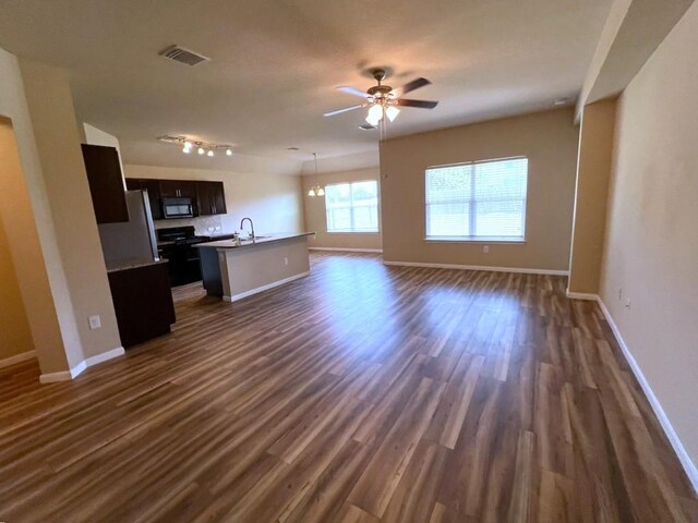 unfurnished living room featuring sink, dark hardwood / wood-style floors, and ceiling fan