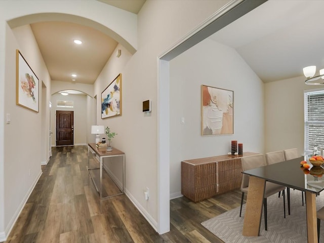 hallway featuring vaulted ceiling and dark wood-type flooring