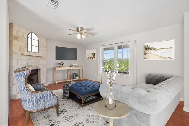 living room with ceiling fan, wood-type flooring, and a fireplace