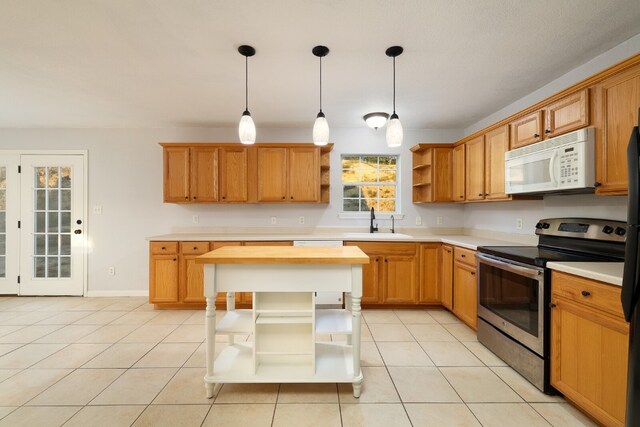 kitchen featuring sink, decorative light fixtures, stainless steel range with electric stovetop, a kitchen island, and light tile patterned floors