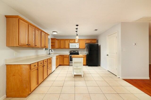 kitchen featuring a center island, light hardwood / wood-style floors, sink, pendant lighting, and white appliances