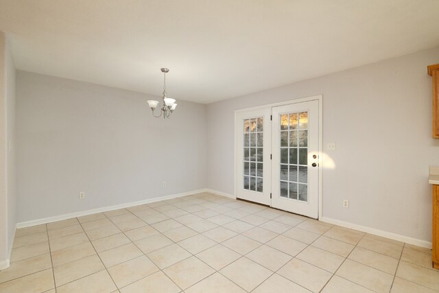 spare room featuring a chandelier and light tile patterned floors