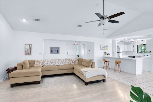 living room featuring light hardwood / wood-style floors, rail lighting, sink, high vaulted ceiling, and ceiling fan