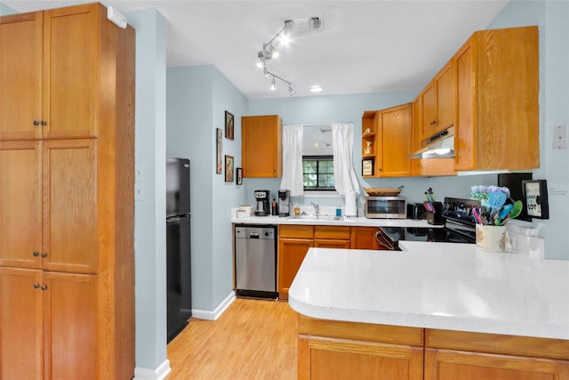 kitchen featuring sink, appliances with stainless steel finishes, light hardwood / wood-style floors, track lighting, and kitchen peninsula