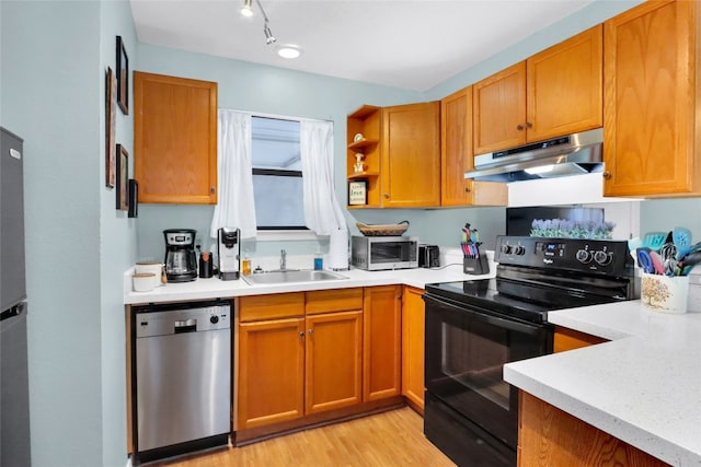 kitchen with sink, appliances with stainless steel finishes, rail lighting, light hardwood / wood-style floors, and exhaust hood