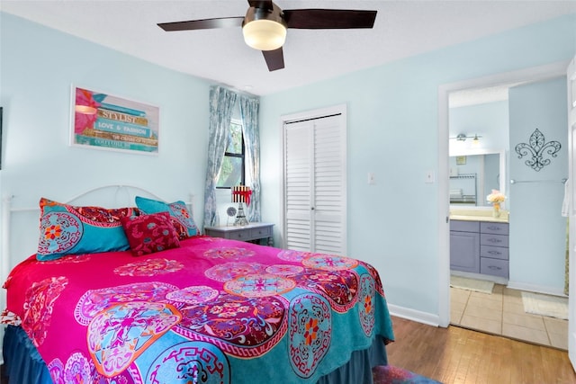 bedroom featuring ceiling fan, hardwood / wood-style flooring, a closet, and ensuite bath