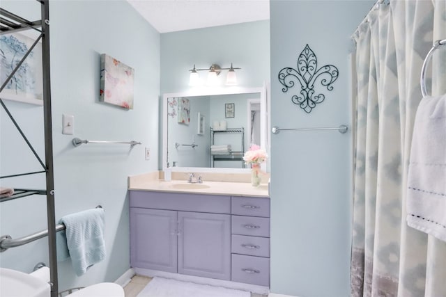 bathroom with a textured ceiling, toilet, vanity, and tile patterned floors