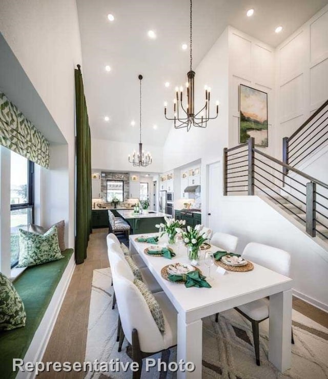 dining area featuring light hardwood / wood-style flooring, a notable chandelier, and high vaulted ceiling