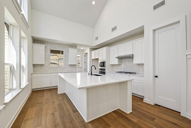 kitchen featuring white cabinetry, appliances with stainless steel finishes, and a center island with sink