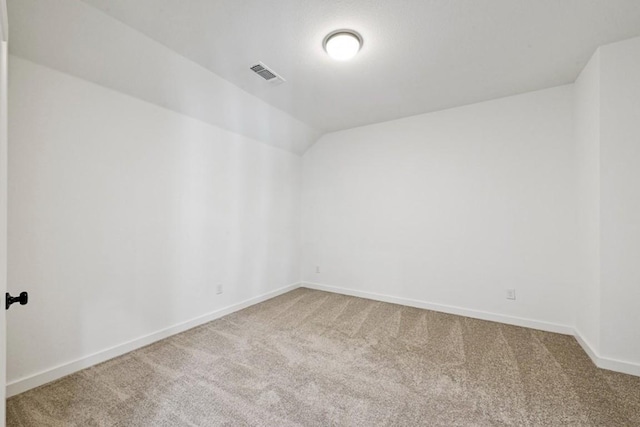 spare room with vaulted ceiling and carpet