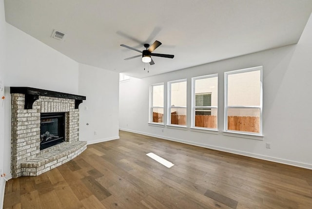 unfurnished living room with hardwood / wood-style flooring, ceiling fan, and a fireplace