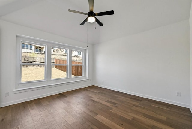 empty room with dark wood-type flooring, ceiling fan, and vaulted ceiling