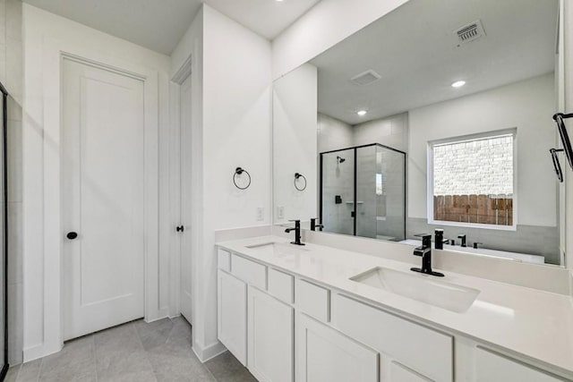 bathroom featuring tile patterned floors, vanity, and a shower with shower door