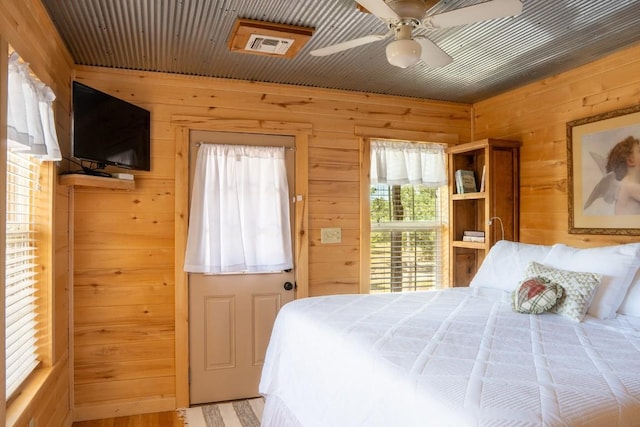 bedroom featuring wood walls and visible vents