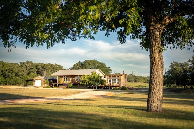 view of property's community featuring an outdoor structure and a lawn