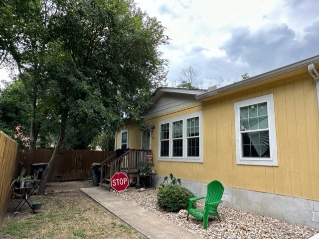 view of side of home featuring fence