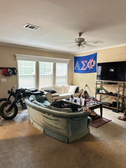 carpeted living room with ceiling fan and ornamental molding