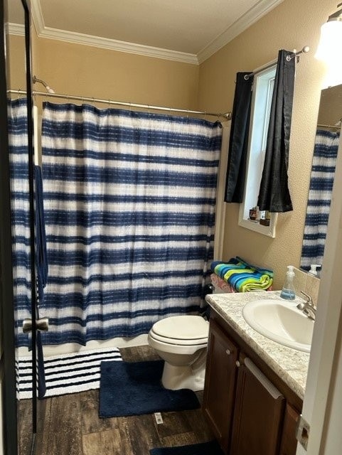 full bathroom featuring vanity, crown molding, toilet, curtained shower, and wood finished floors