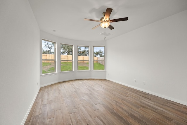 unfurnished room with visible vents, baseboards, and wood finished floors