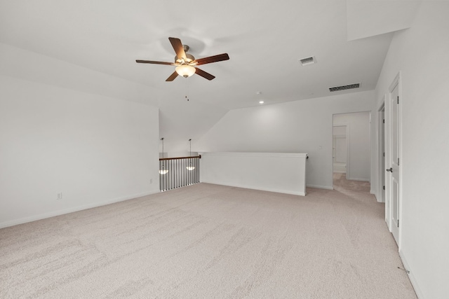 additional living space with light carpet, ceiling fan, vaulted ceiling, and visible vents