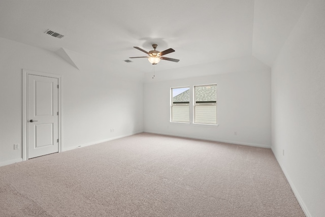 carpeted spare room featuring ceiling fan and vaulted ceiling