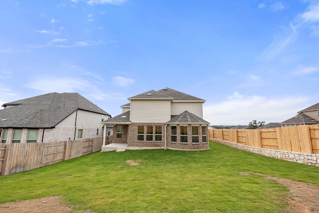 rear view of house featuring a yard