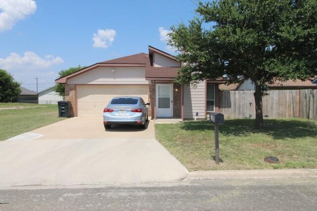 view of front of property featuring a front lawn and a garage