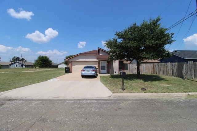 ranch-style home with an attached garage, concrete driveway, a front yard, and fence