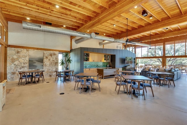 dining room with beam ceiling and a towering ceiling