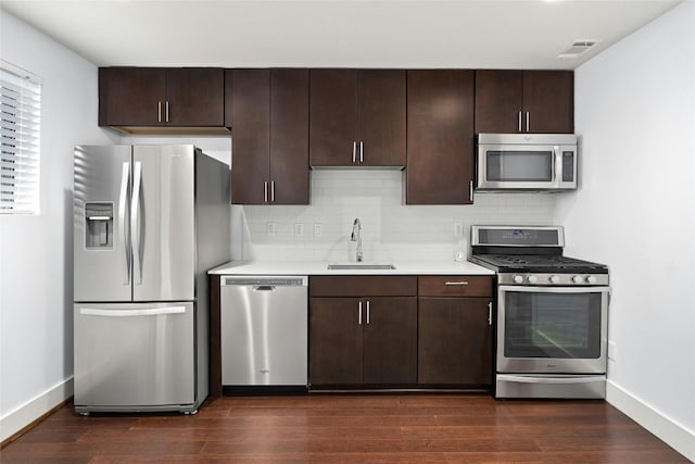 kitchen featuring dark brown cabinetry, stainless steel appliances, and dark hardwood / wood-style flooring