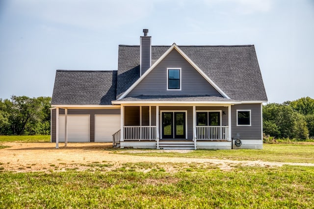 view of front facade with covered porch, a garage, and a front lawn