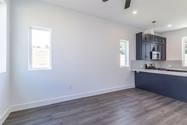 kitchen featuring backsplash, ceiling fan, hardwood / wood-style floors, and stove