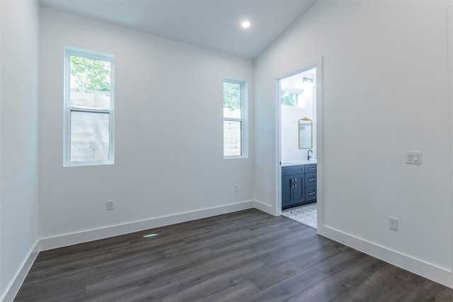 unfurnished room featuring lofted ceiling and dark hardwood / wood-style flooring