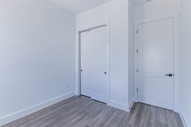 unfurnished bedroom with hardwood / wood-style floors and a closet